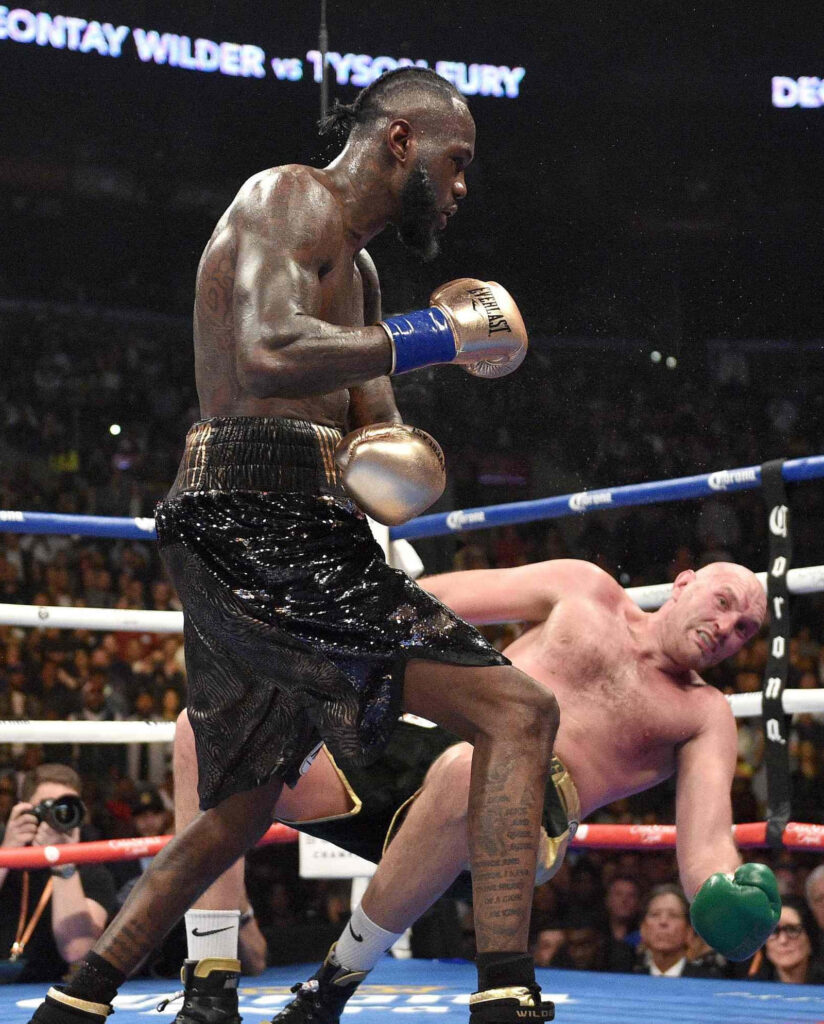 Deontay Wilder vs Tyson Fury boxing match intense moment with bright arena lights wallpaper