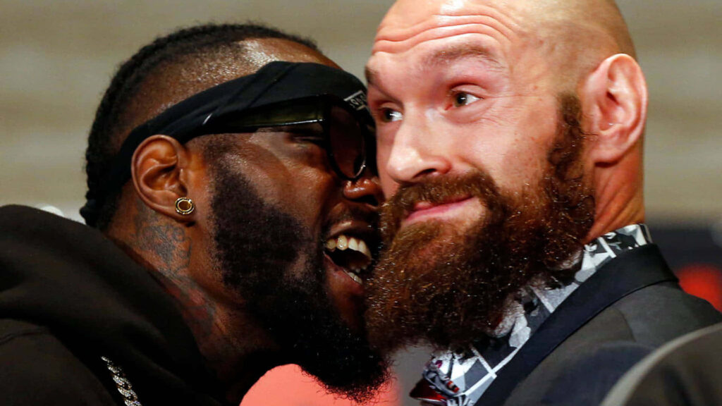 Deontay Wilder angrily confronts Tyson Fury in intense boxing rivalry wallpaper background