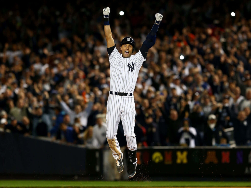 Derek Jeter jumping in New York Yankees uniform celebrating victory under stadium lights Wallpaper