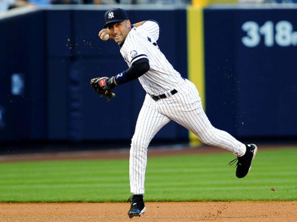 Derek Jeter throwing baseball in Yankee pinstripes with vivid green field and blue outfield wall Wallpaper
