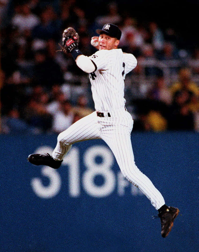 Derek Jeter jumping catch in Yankees pinstripes at baseball stadium showcasing athleticism Wallpaper