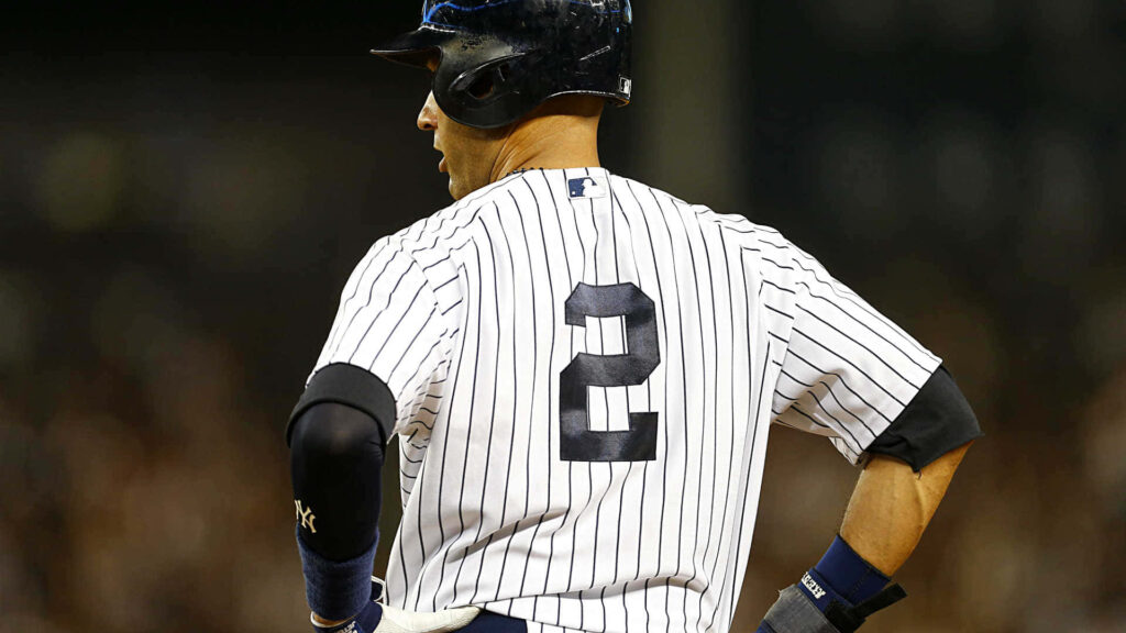 Derek Jeter in number 2 Yankees pinstripe jersey standing focused on baseball field wallpaper