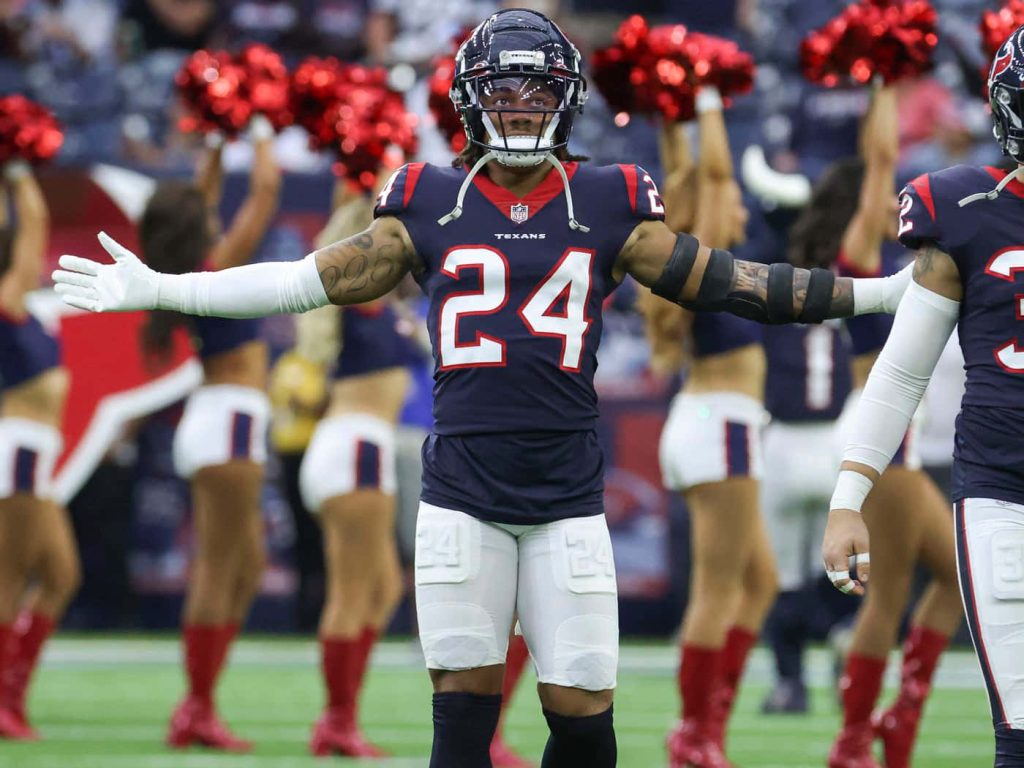 Derek Stingley Jr Houston Texans jersey 24 celebrating on field with bright stadium lights background Wallpaper