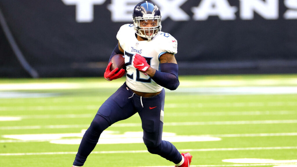 Derrick Henry Tennessee Titans charging on green field intense focus football wallpaper background