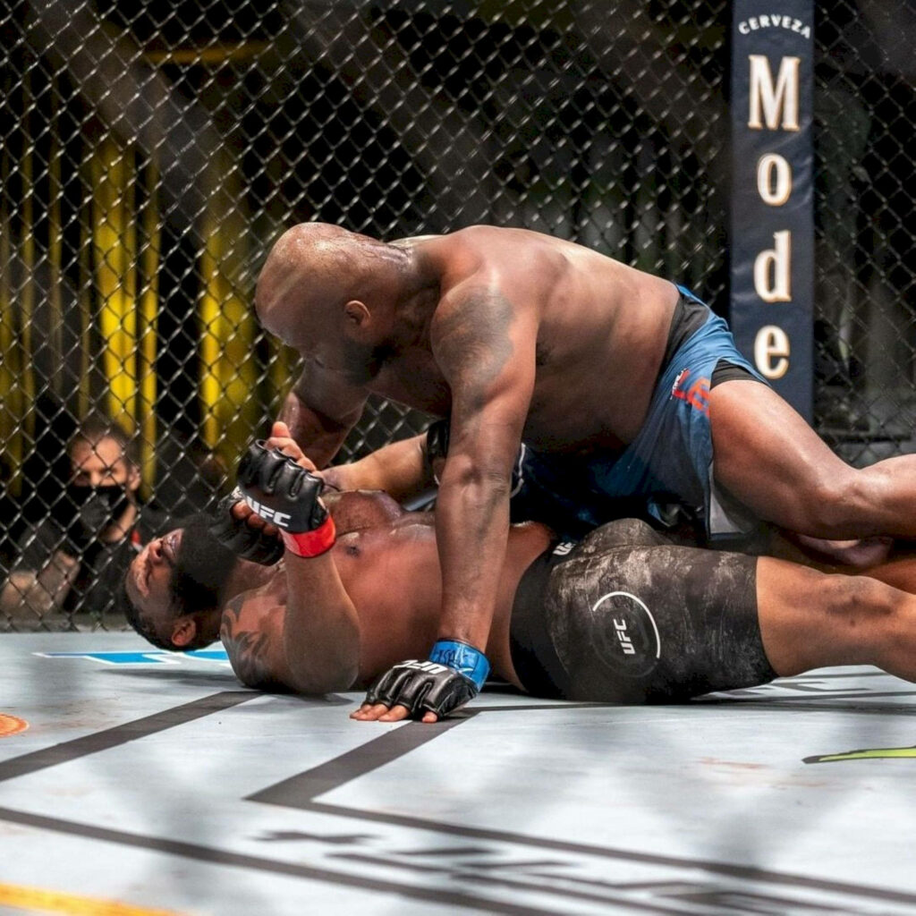 Derrick Lewis dominating Curtis Blaydes in intense UFC octagon fight with dramatic lighting Wallpaper