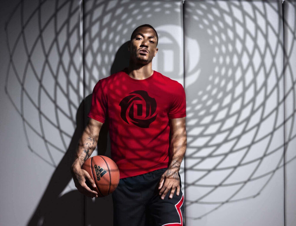 Derrick Rose in red jersey holding basketball with dynamic shadows and geometric sports background Wallpaper