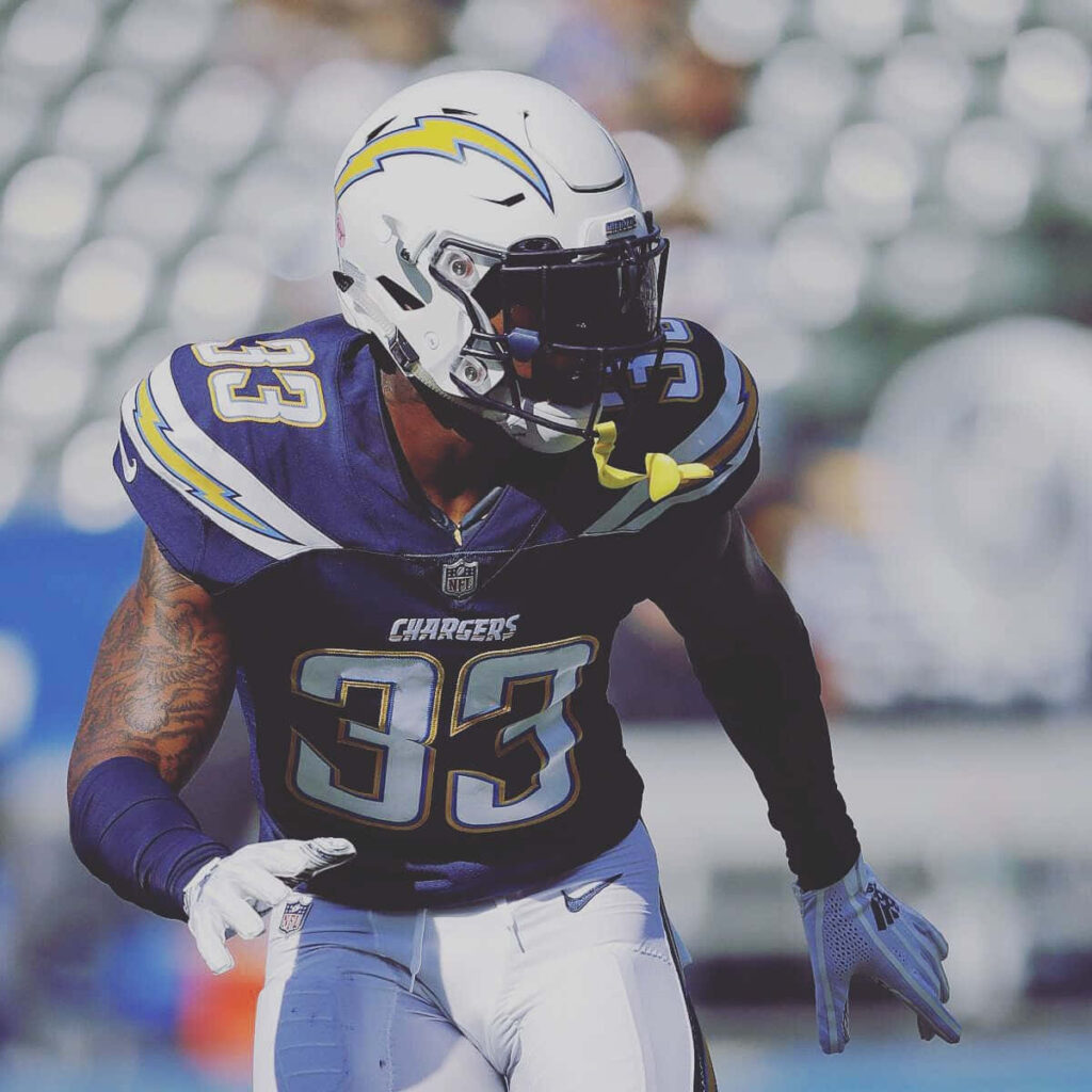 Derwin James Jr Chargers action wallpaper dark blue uniform lightning stadium background energy