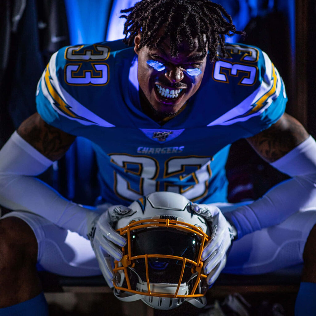 Derwin James Jr in Chargers uniform with intense expression vibrant blue purple lighting wallpaper
