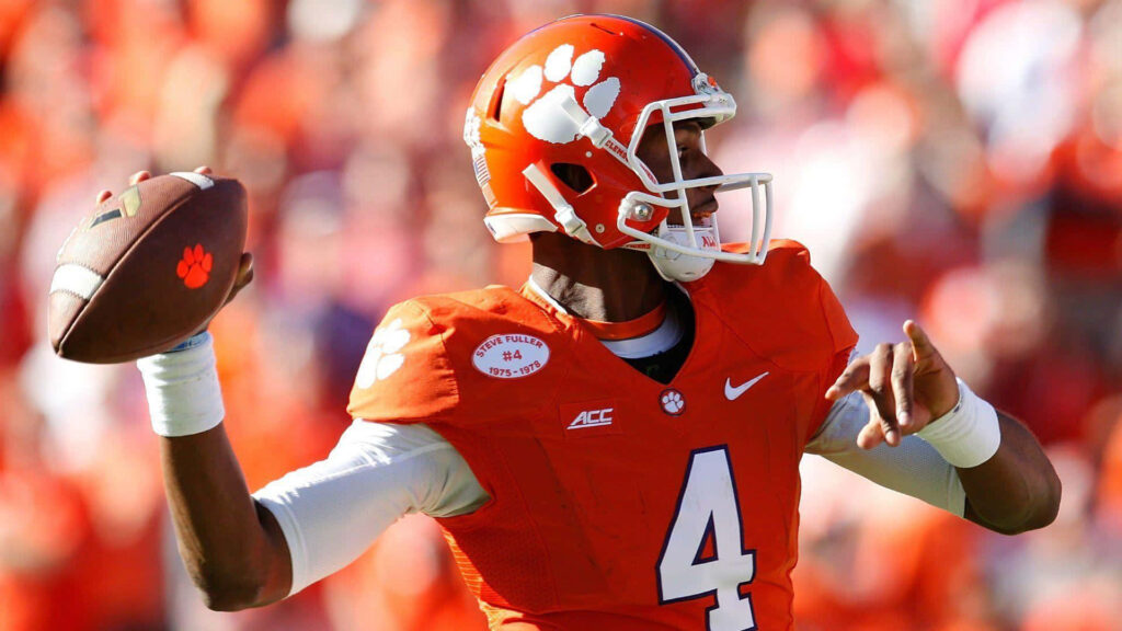 Deshaun Watson in number 4 jersey throws pass for Clemson Tigers in bright orange gear Wallpaper