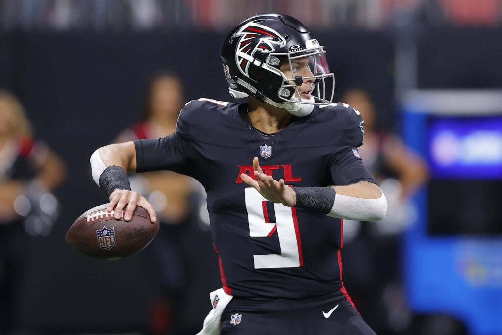 Desmond Ridder Atlanta Falcons quarterback mid-throw in black uniform on stadium field action pose Wallpaper