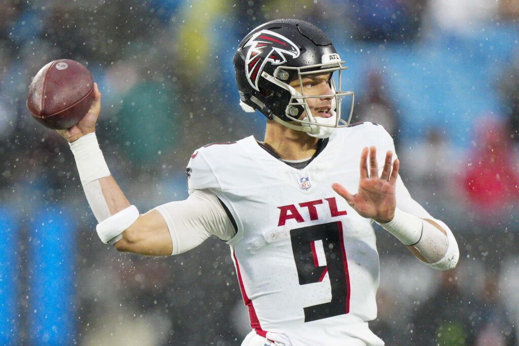 Desmond Ridder Atlanta Falcons quarterback mid-throw in white uniform dynamic football action Wallpaper