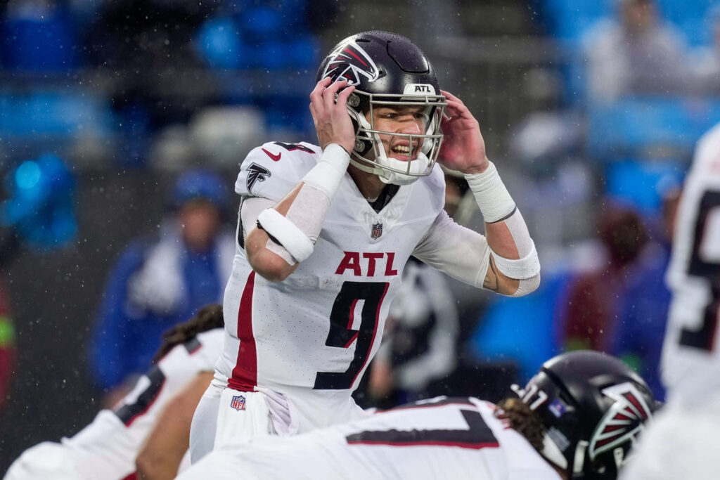 Desmond Ridder Atlanta Falcons quarterback in white and red uniform focused during snowy NFL game Wallpaper
