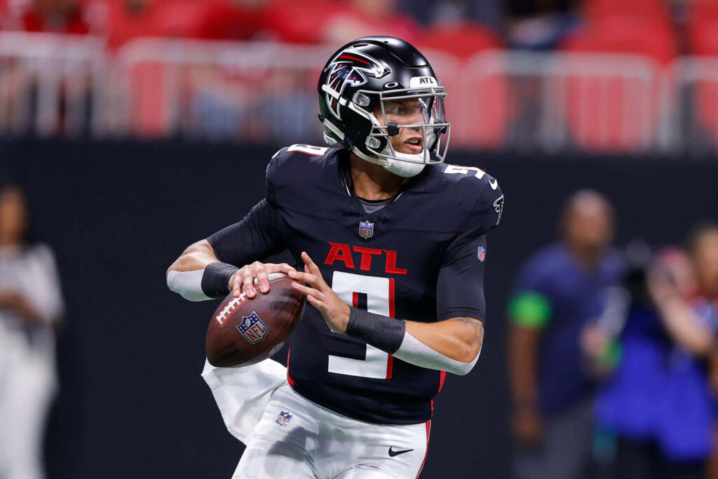 Desmond Ridder Atlanta Falcons quarterback in black uniform ready to throw football stadium background Wallpaper