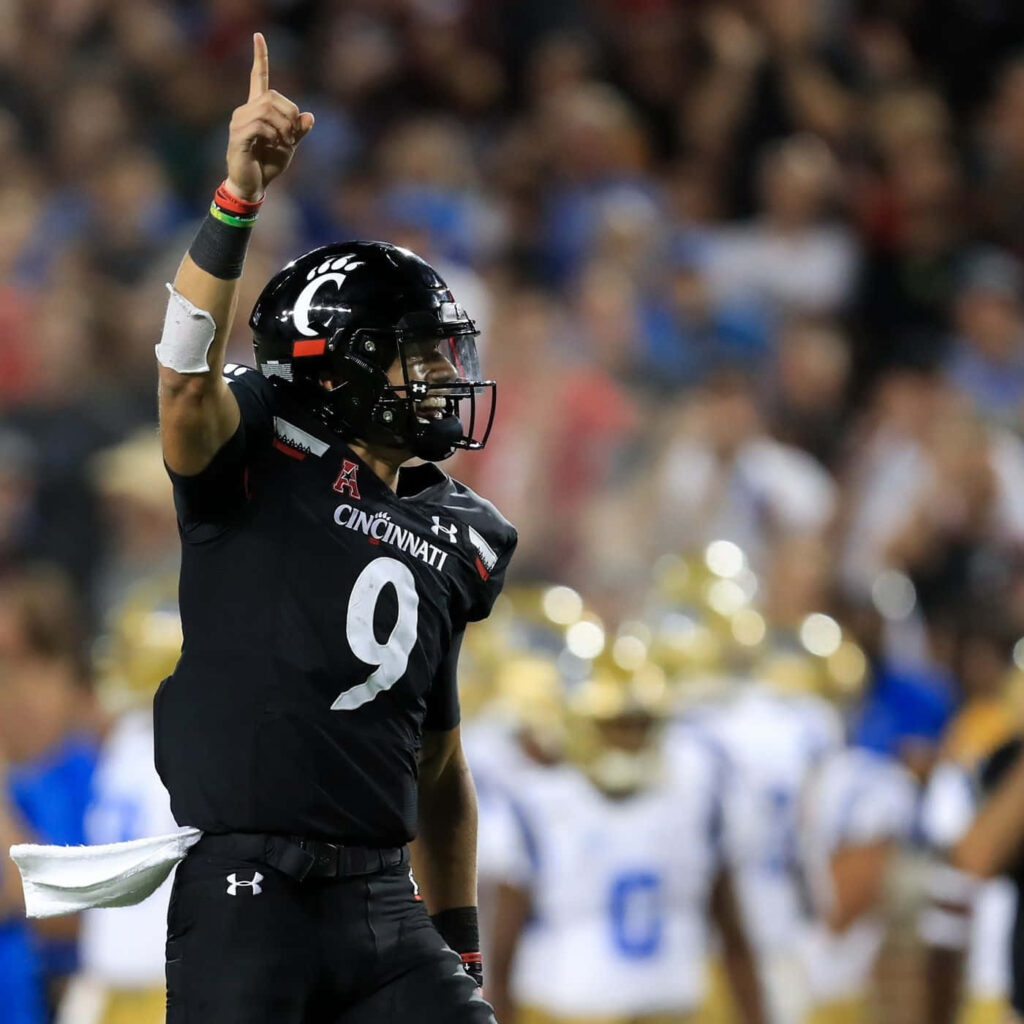 Desmond Ridder celebrating as Cincinnati quarterback in black uniform number 9 at vibrant stadium Wallpaper