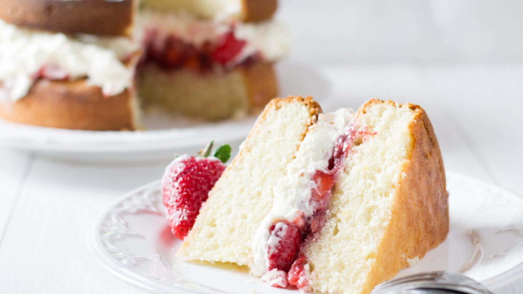 Savoring Delight: Tempting Strawberry Sponge Cake on a Serene Dessertscape Wallpaper