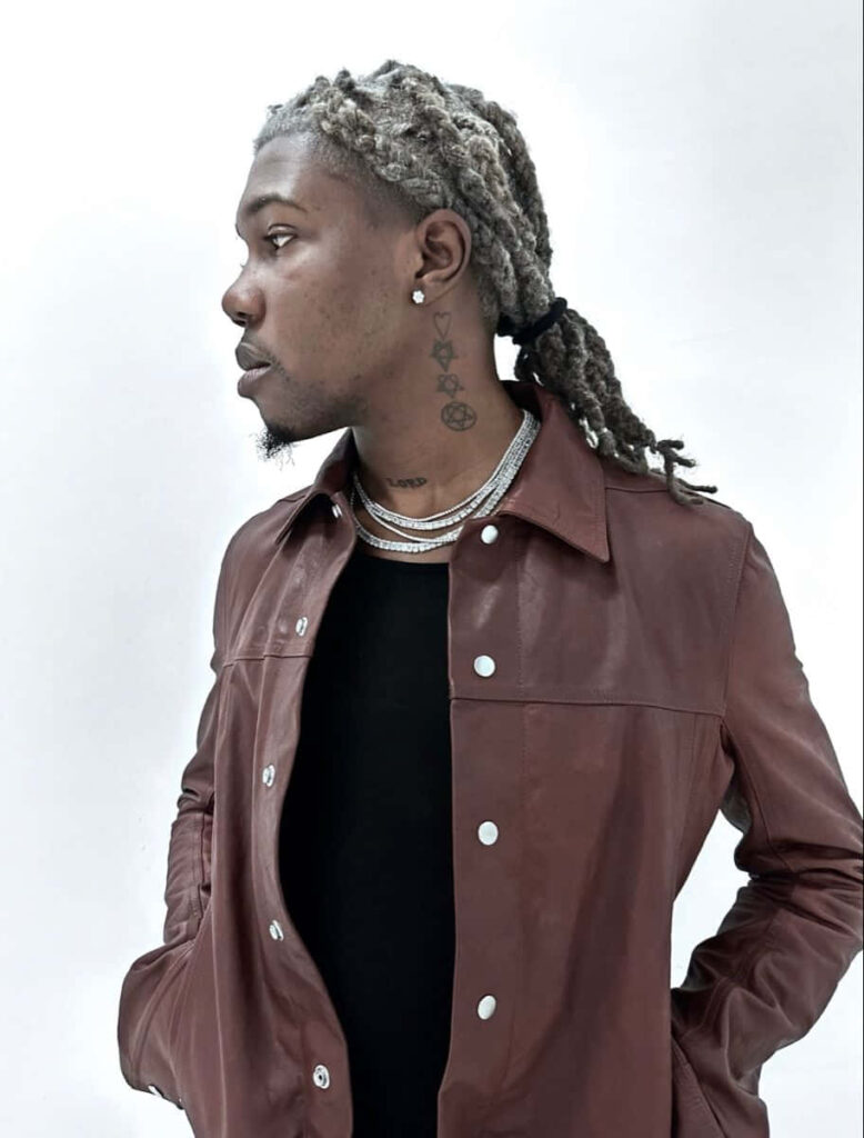 Destroy Lonely stylish portrait with brown leather jacket silver chains white background wallpaper