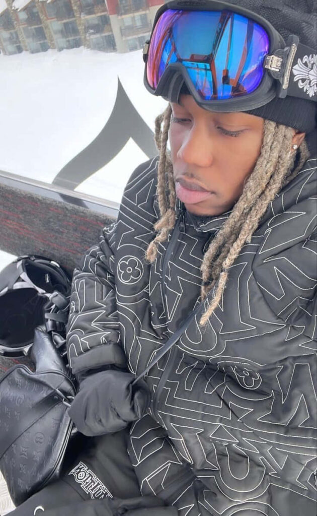 Destroy Lonely in designer black jacket ski goggles blonde dreadlocks snowy urban winter wallpaper