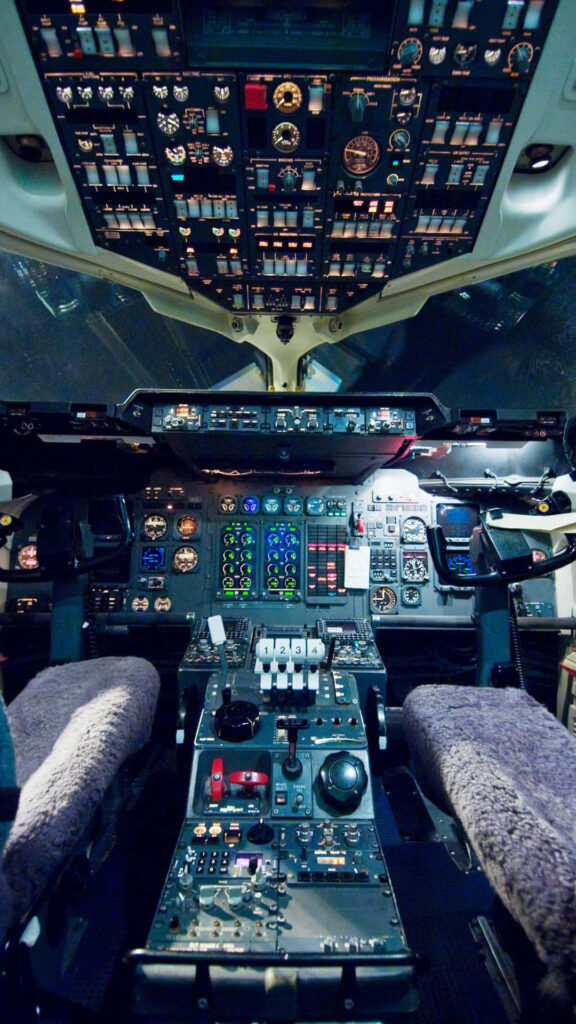 Intricate airplane cockpit with illuminated controls and instrument panels showcasing aviation technology Wallpaper