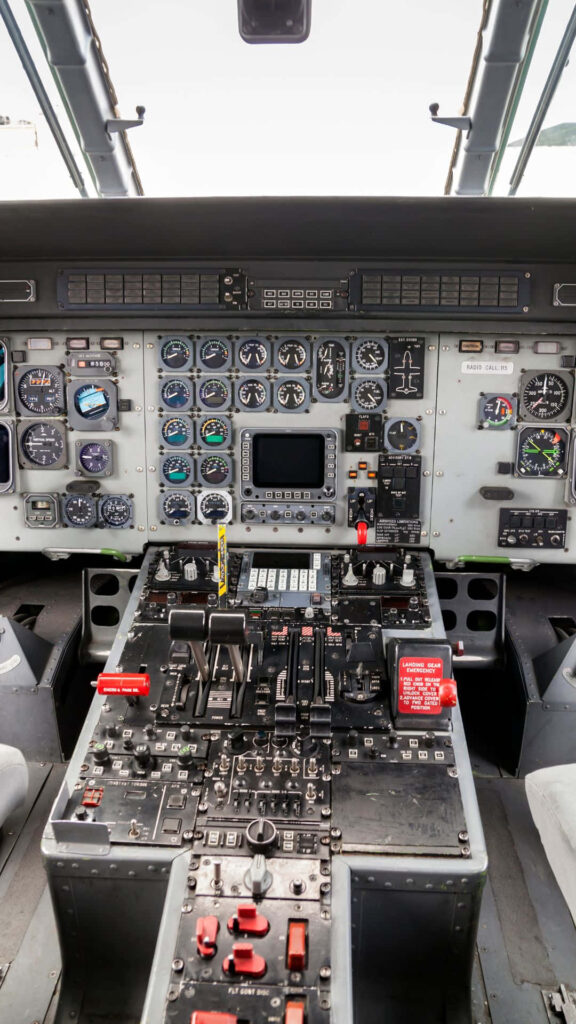 Commercial airplane cockpit interior with detailed analog dials switches and controls wallpaper