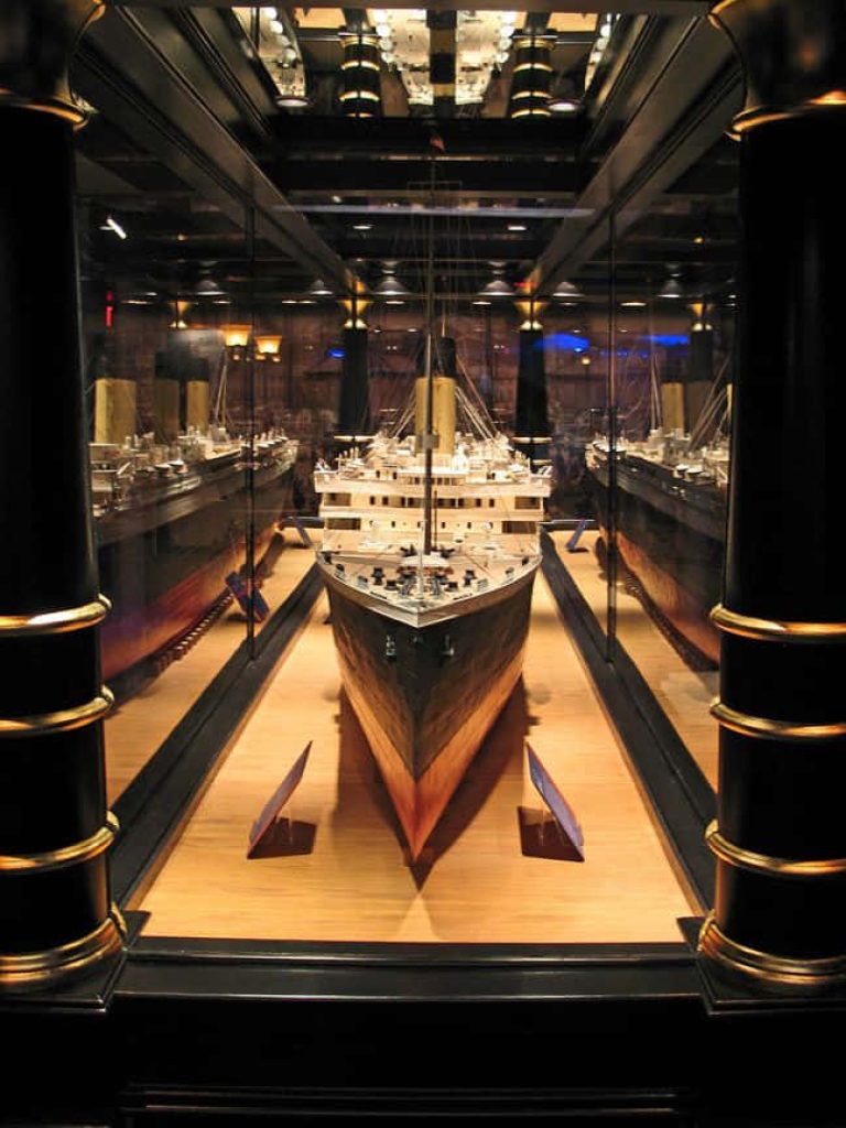 Detailed front view of RMS Titanic scale model in warm lighting at museum exhibit display Wallpaper