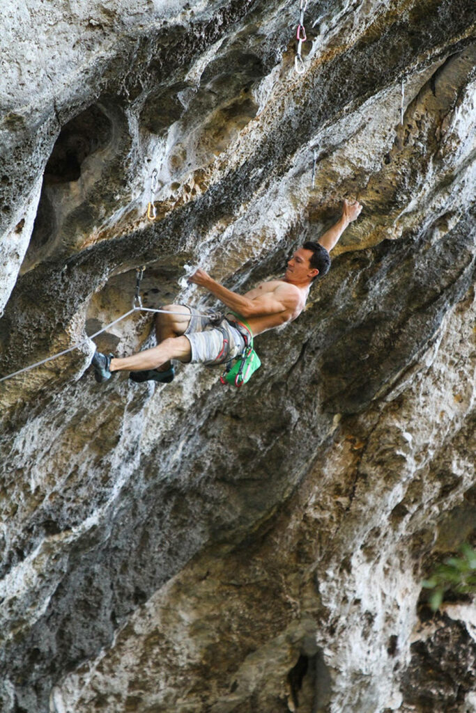 Sport climber scaling rugged rock face showing strength agility extreme backpacking wallpaper