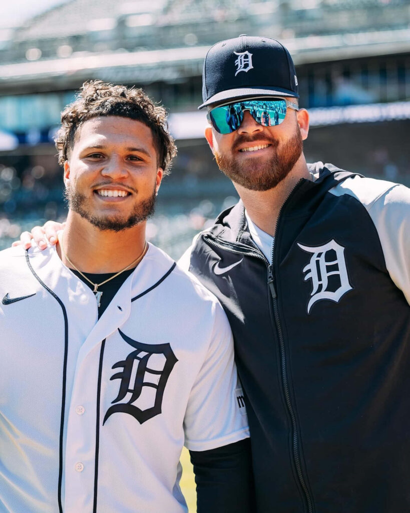 Two Detroit Tigers fans smiling at the stadium wearing Detroit Tigers gear and showing team spirit Wallpaper