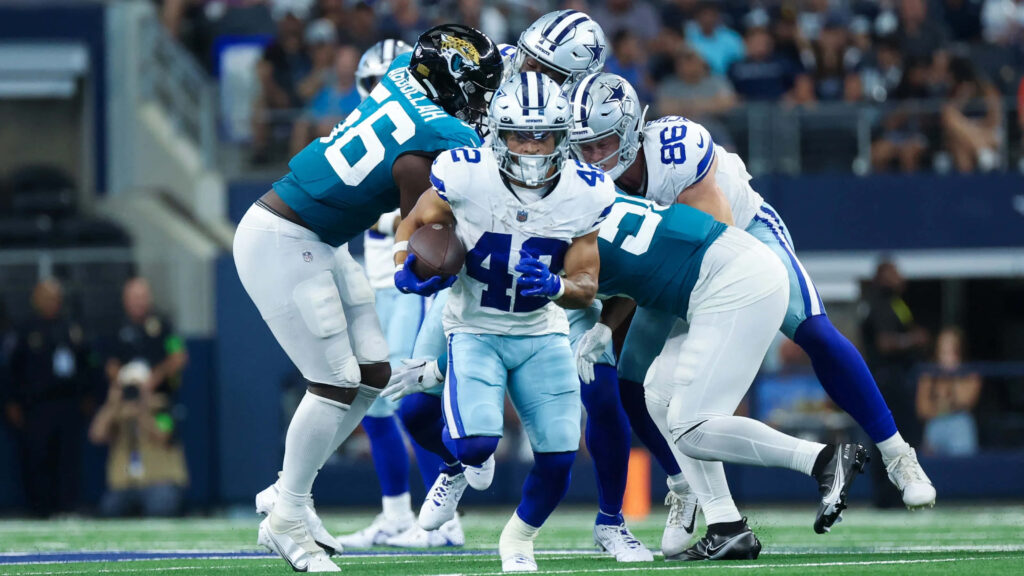 Deuce Vaughn runs past defenders in Dallas Cowboys uniform during intense NFL football game action Wallpaper