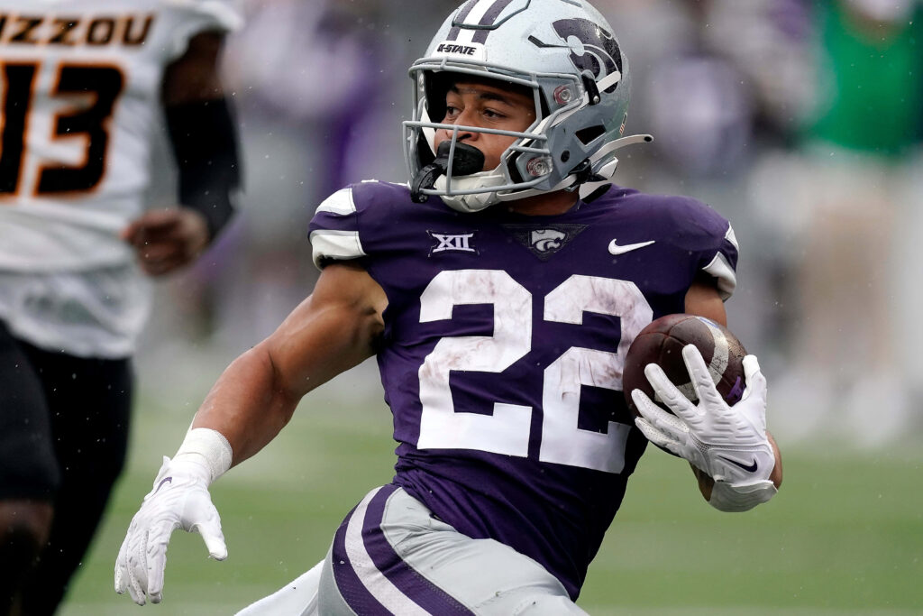 Deuce Vaughn running mid-play in Kansas State Wildcats purple number 22 football uniform wallpaper