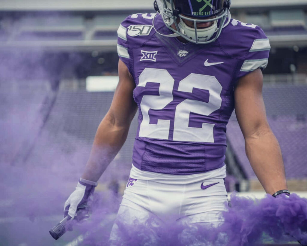 Deuce Vaughn Kansas State Wildcats wallpaper with dynamic purple smoke and intense action pose