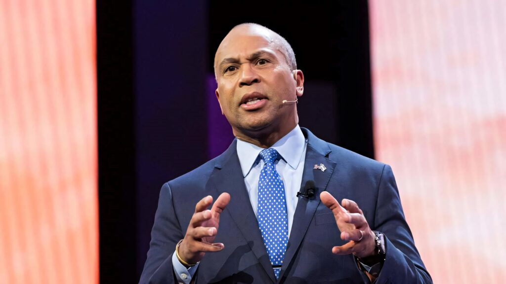 Deval Patrick in sharp blue suit and polka dot tie speaking on stage with intense focused expression Wallpaper