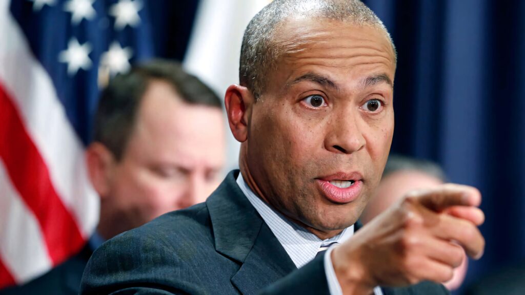 Deval Patrick speaking passionately with American flag and officials behind in official setting Wallpaper