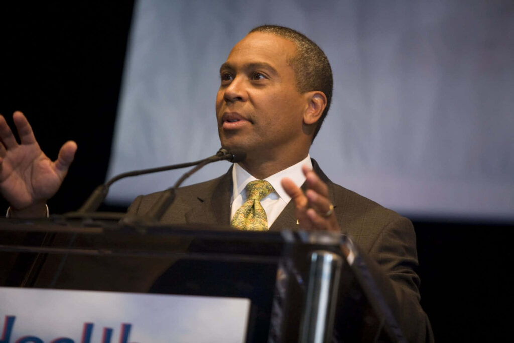 Deval Patrick speaking passionately at podium with warm lighting inspiring leadership and confidence Wallpaper