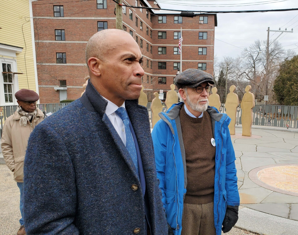 Deval Patrick in formal coat outdoors with confused look urban apartments winter scene background Wallpaper