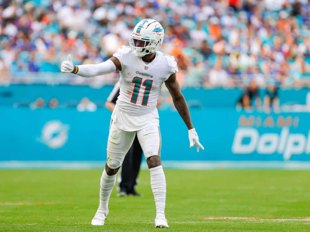 Devante Parker Miami Dolphins white uniform ready on field intense game action vibrant stadium fans Wallpaper