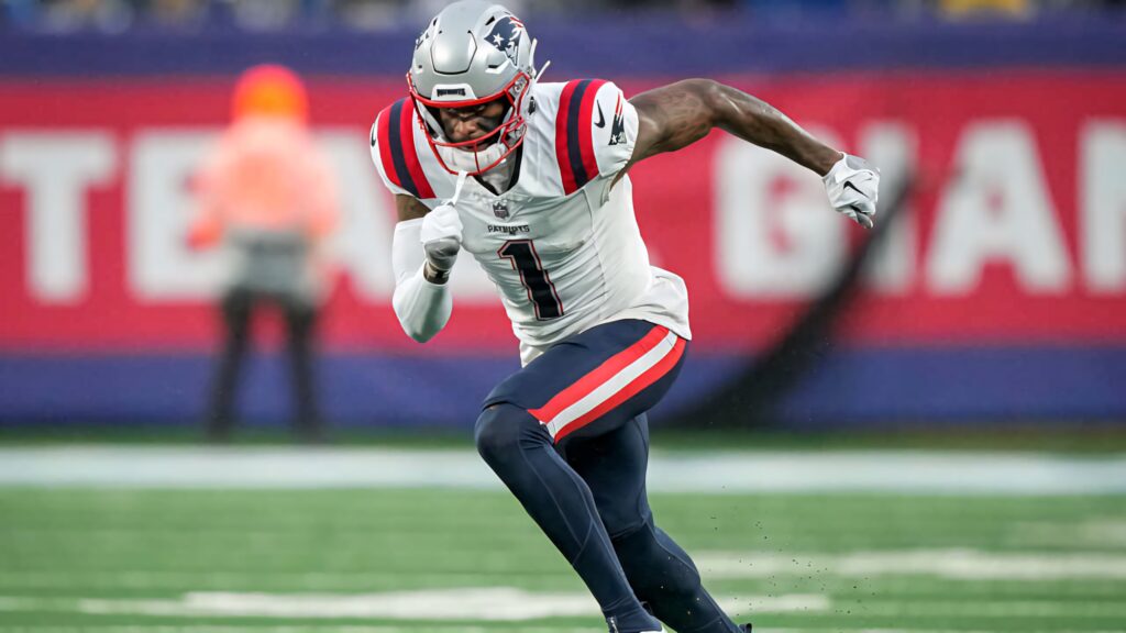 Devante Parker New England Patriots running fast in vibrant jersey with blurred stadium background Wallpaper