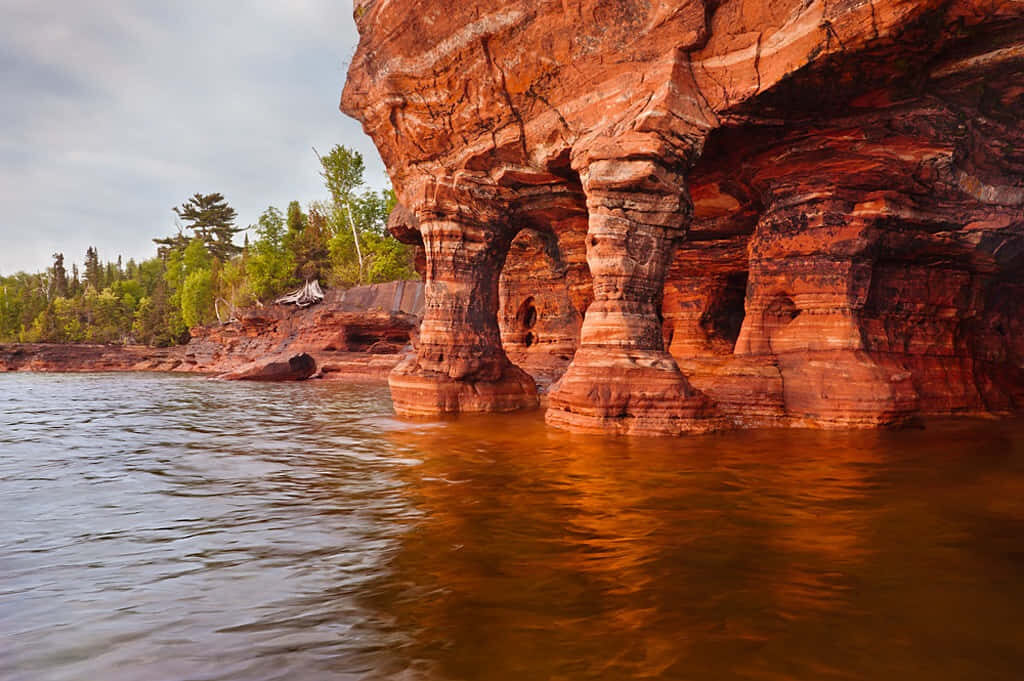 Tranquil Devils Island Sandstone Caves: Serene Sunset Wallpaper