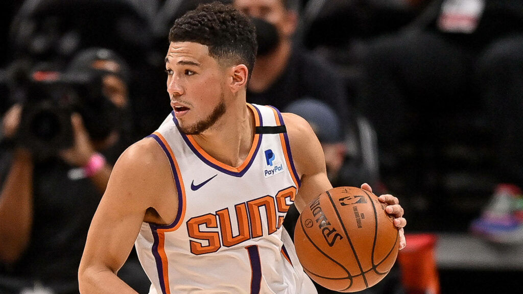 Devin Booker Phoenix Suns basketball action side view intense focus dynamic arena lighting Wallpaper