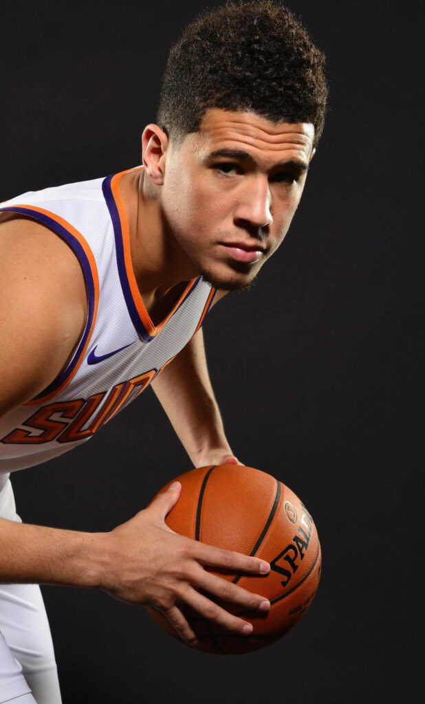 Devin Booker Phoenix Suns close-up holding basketball intense focus NBA star portrait wallpaper