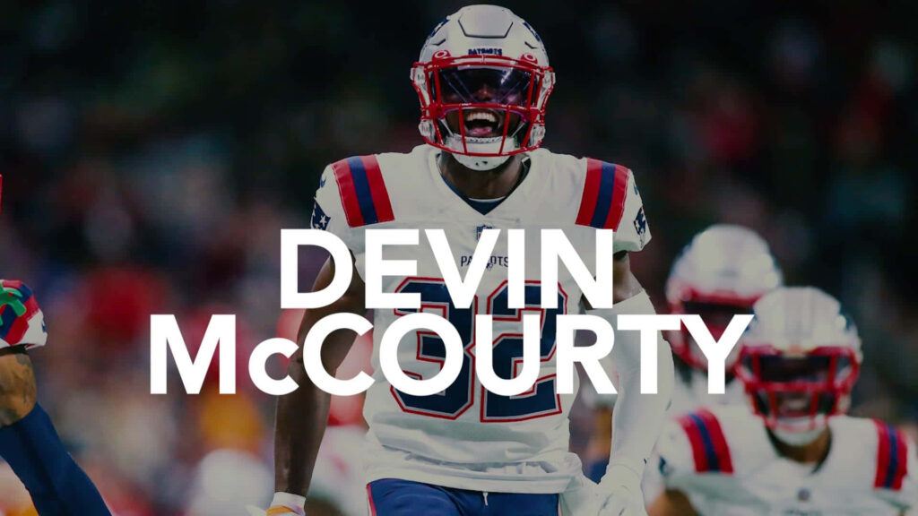 Devin McCourty New England Patriots in full uniform charging forward with focus and intensity Wallpaper