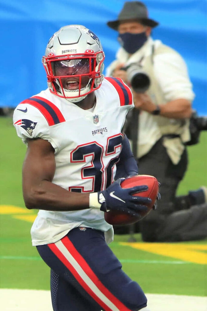 Devin McCourty in New England Patriots uniform gripping football focused on field action wallpaper
