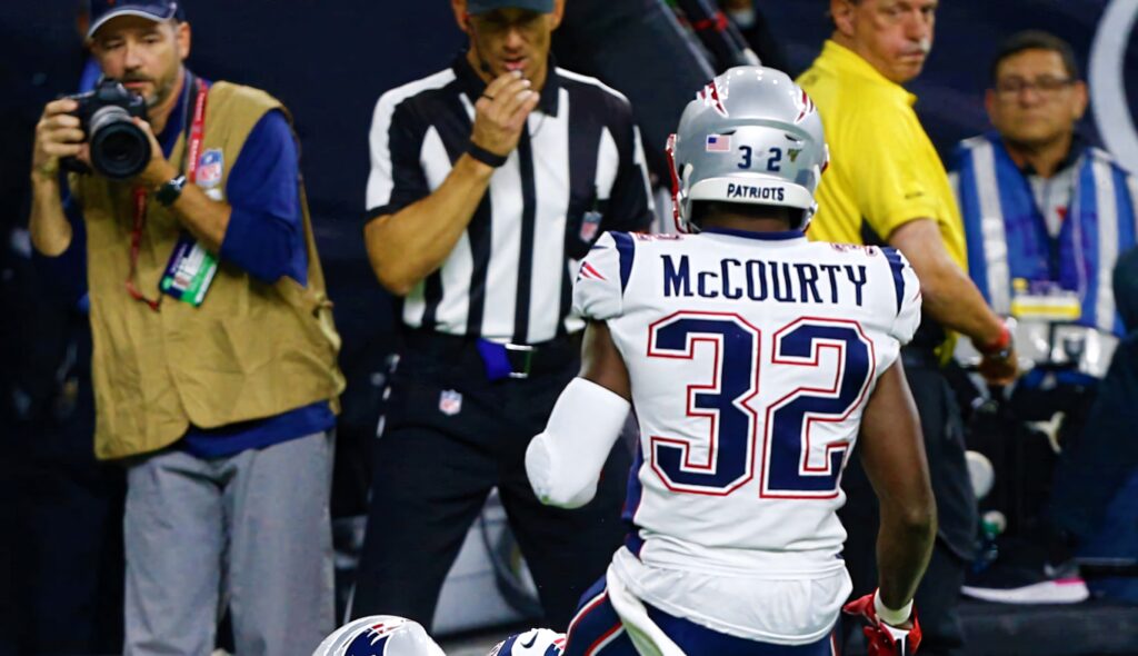 Devin McCourty in Patriots uniform focused and dynamic action during an intense NFL game Wallpaper