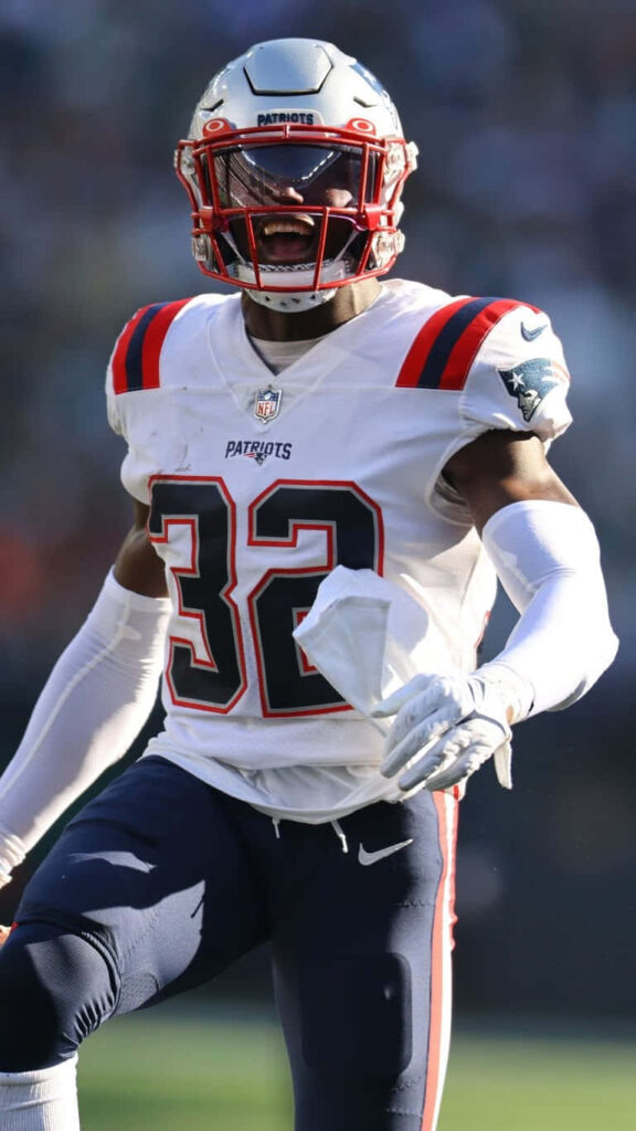 Devin McCourty Patriots uniform mid-action intense athleticism navy red white stadium background Wallpaper