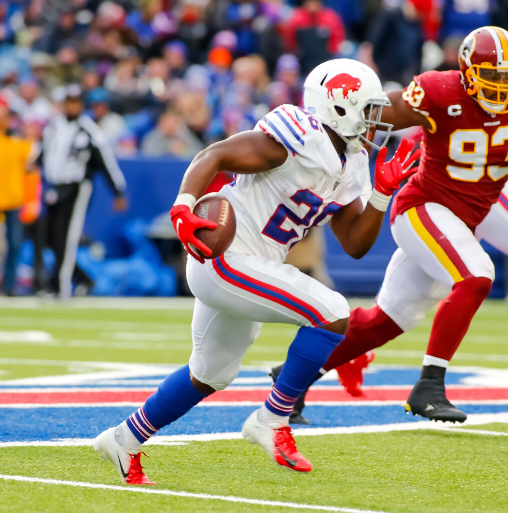 Devin Singletary Buffalo Bills powerful run NFL game action vibrant uniform blurred crowd Wallpaper