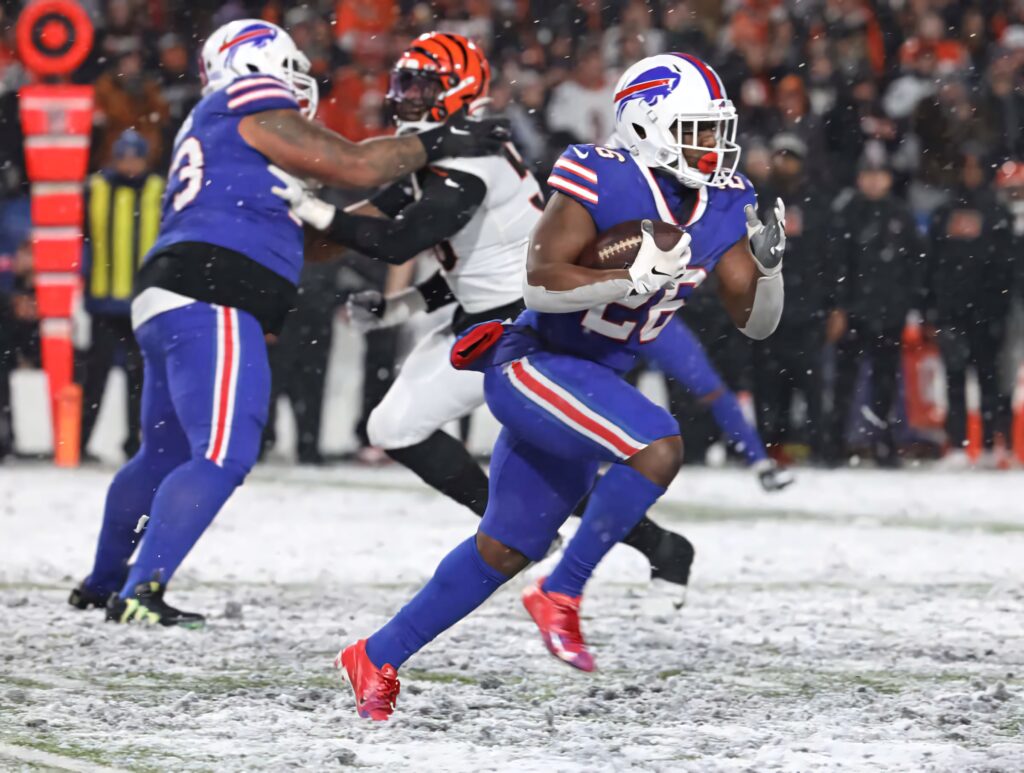 Devin Singletary Buffalo Bills running through snow during intense winter NFL game action wallpaper