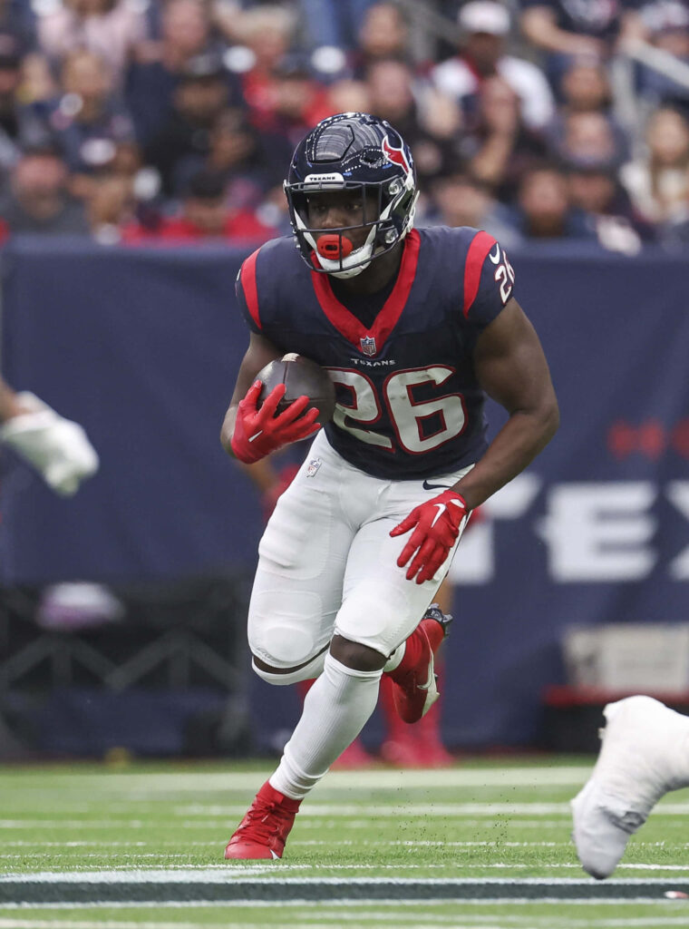 Devin Singletary Houston Texans charging down field football action vibrant red blue uniform Wallpaper