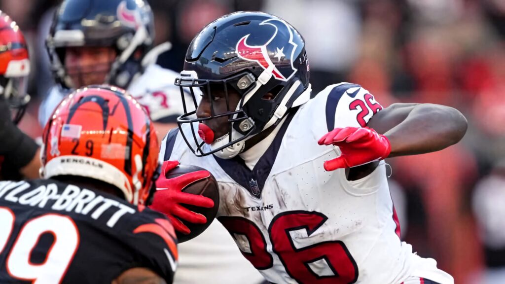 Devin Singletary NFL running back bursts through defenders intense football action wallpaper