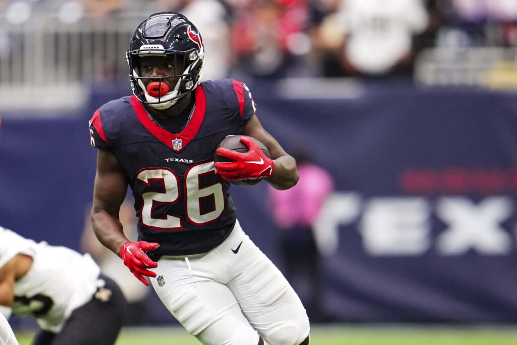 Devin Singletary Texans football player number 26 charging forward in intense NFL action wallpaper