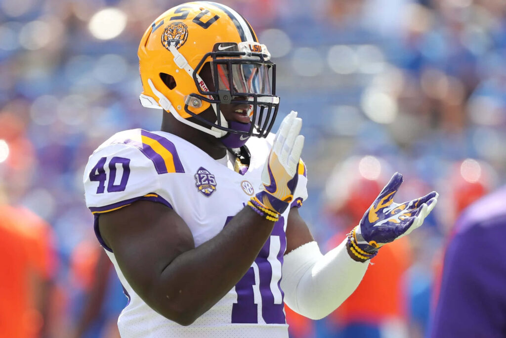 LSU football linebacker Devin White clapping in yellow helmet white uniform vibrant stadium wallpaper