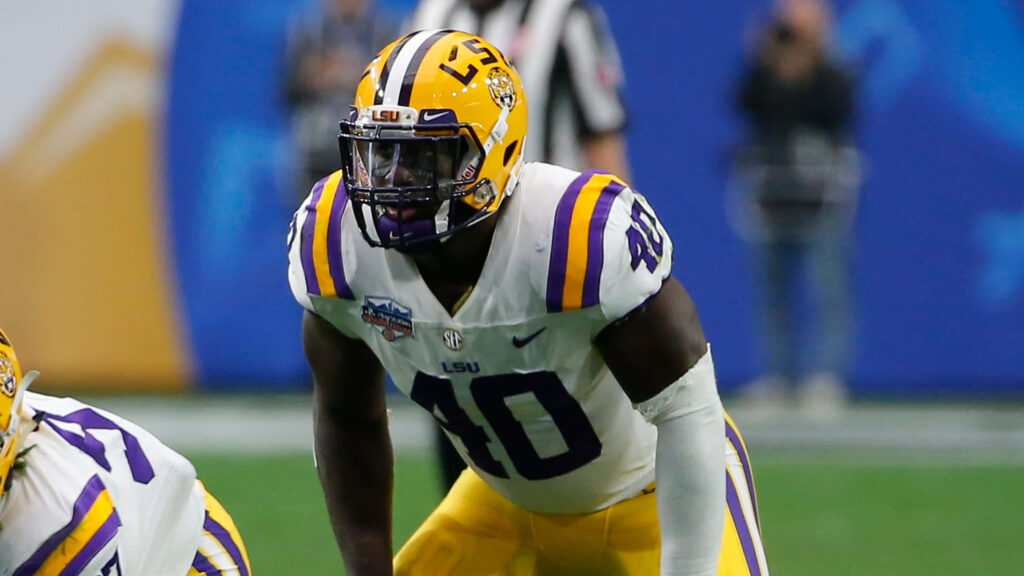 LSU linebacker Devin White in purple and gold uniform ready on football field game day wallpaper