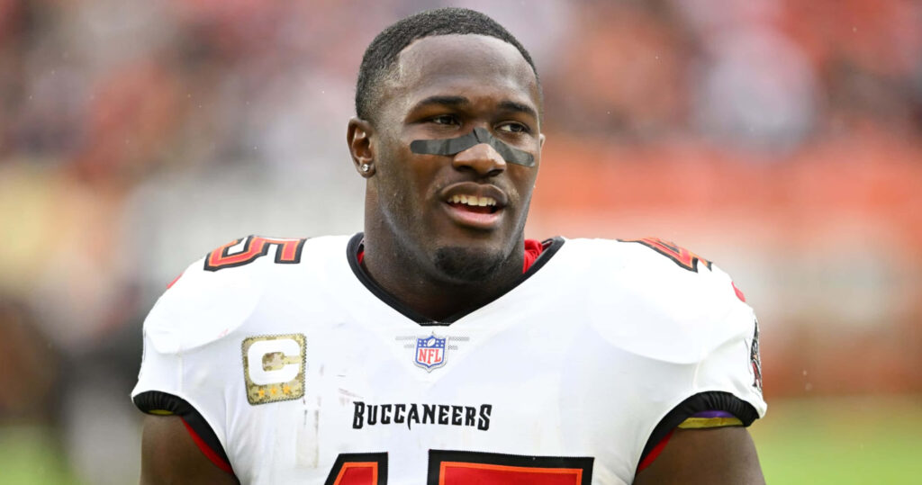Devin White Tampa Bay Buccaneers linebacker in red pewter uniform focused on NFL game field Wallpaper